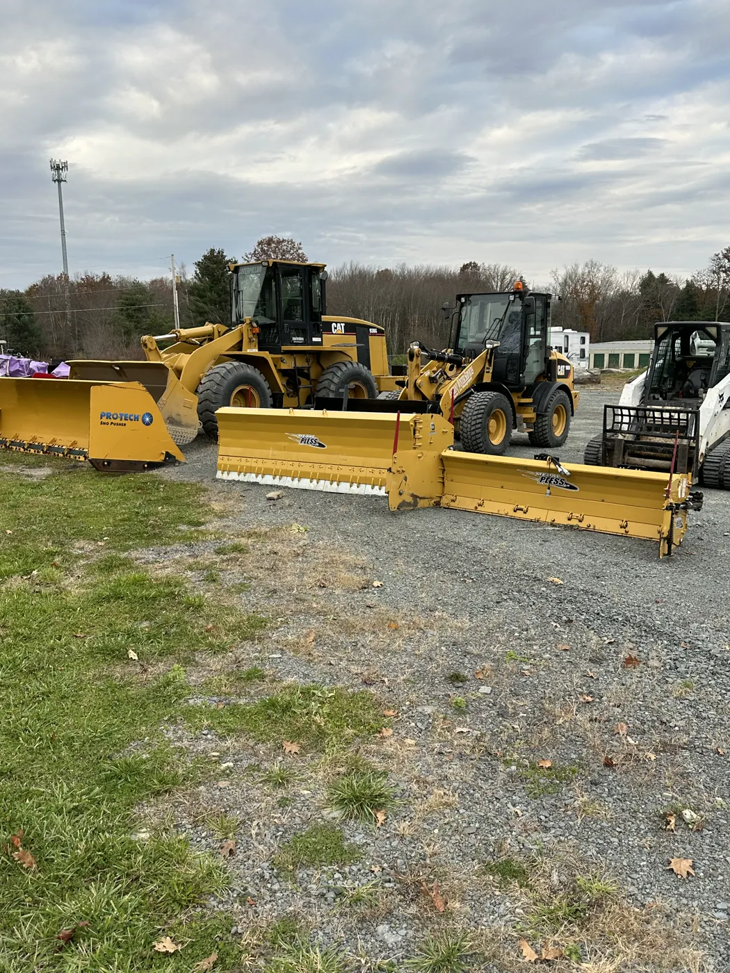 Wheel loaders and containment pushers staged on gravel before the season