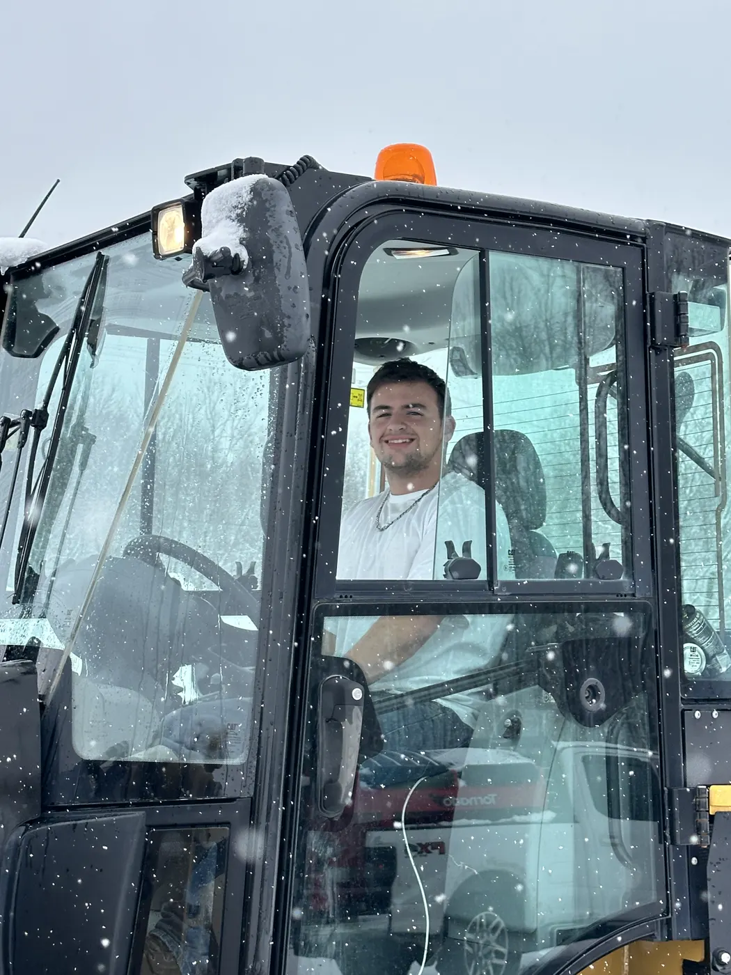 Operator smiling from the cab of a loader