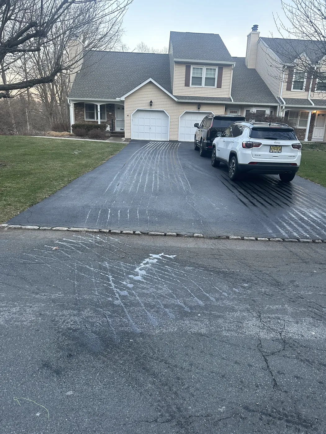 Residential driveway plowed clean in front of a two-story home