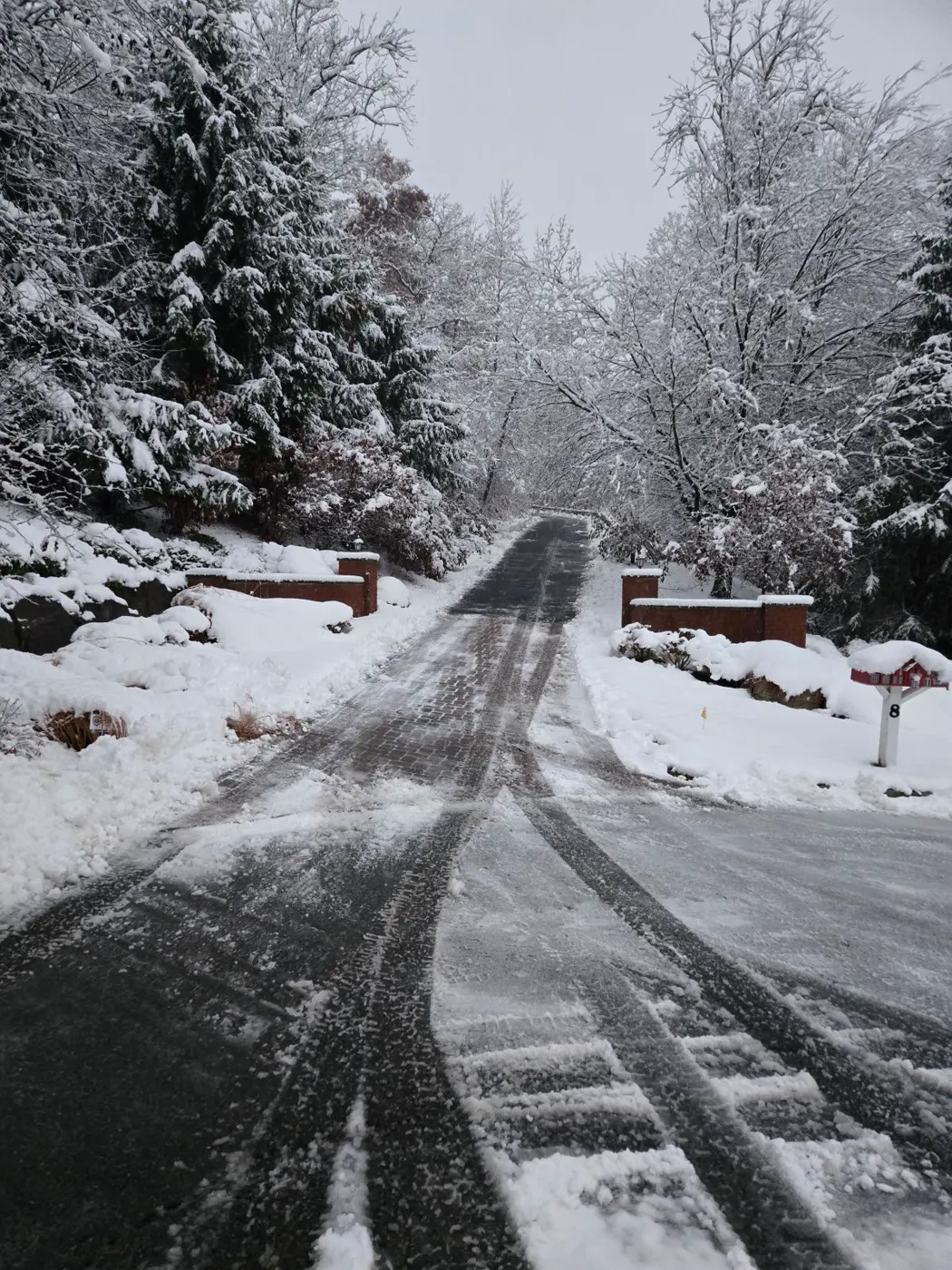 Snow-covered front yard and driveway seen from the plow truck