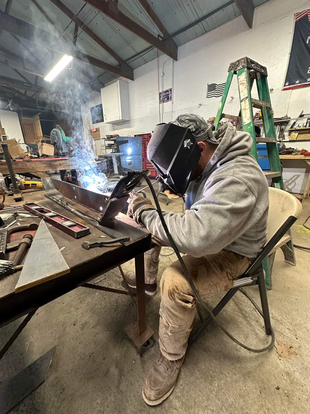 Technician welding plow parts in the shop